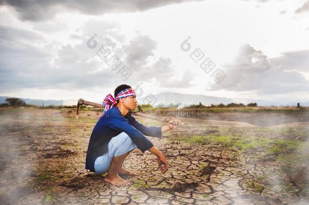 不抱希望的农场主一次向干的干燥的地面和锄头向他的肩膀一