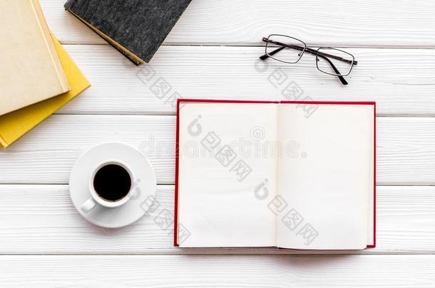 工作场所和书,眼镜,咖啡豆向白色的木制的背景