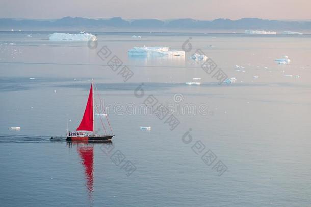 小的红色的帆船巡航的经过不固定的冰山采用迪斯科波黑