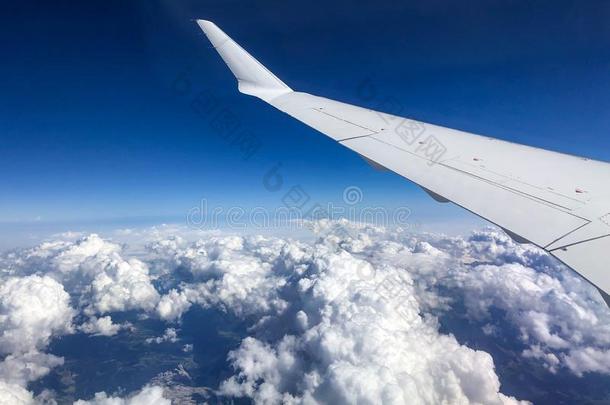 白色的飞机翅膀越过多云的天和看法关于地平线.完美的