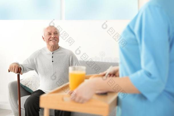 护士服务早餐向上了年纪的男人.帮助较高的人