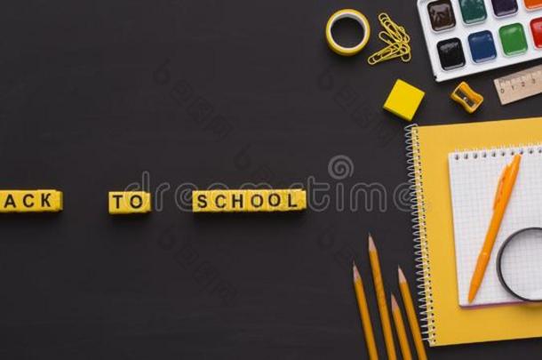 黄色的有色的学校日用品和背向学校文本