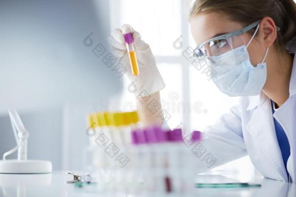 女人研究员是（be的三单形式被环绕着的在旁边医学的小瓶和瓶,是（be的三单形式ol