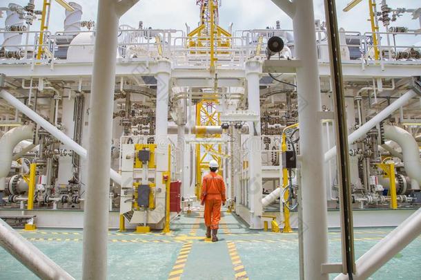 技术人员步行通过海上的油和气体过程为检查