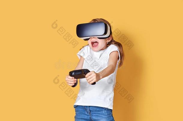 女孩体验VirtualReality虚拟现实戴在头上的耳机或听筒versus对操纵杆游戏向黄色的后台