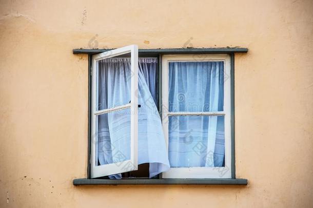 敞开的窗扉窗采用老的粉饰灰泥房屋和白色的纱布偏航