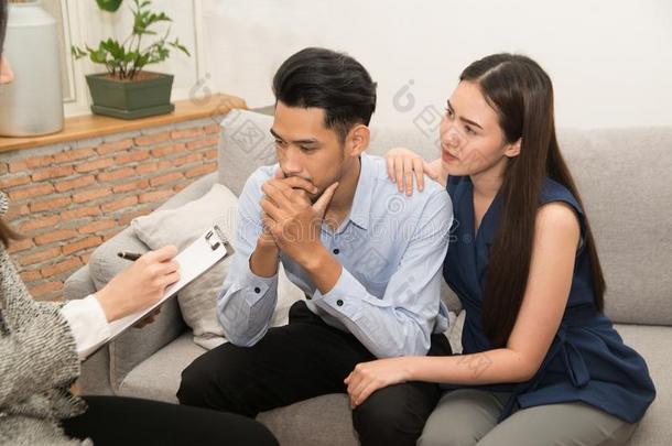 亚洲人女人可安慰的他的丈夫一次向长沙发椅和心理医生