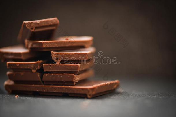 巧克力条堆积向指已提到的人黑暗的背景/关在上面浓情巧克力