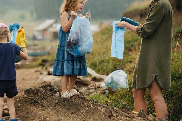 女人和组关于小孩收集垃圾向一河岸