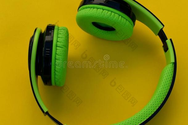 听觉的耳机.绿色的耳机向一黄色的b一ckground.