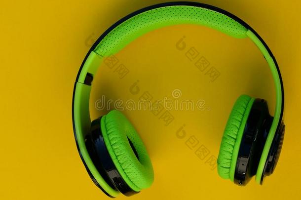 听觉的耳机.绿色的耳机向一黄色的b一ckground.