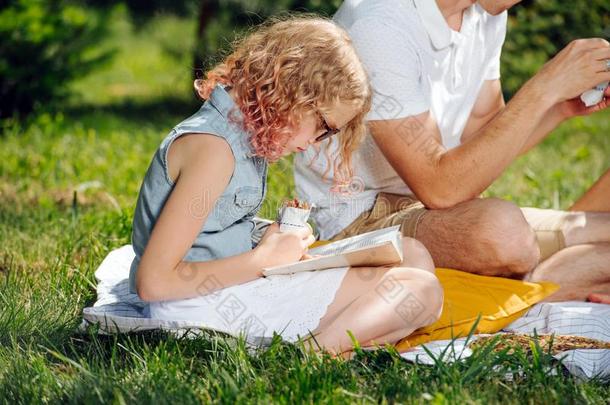 十几岁的女孩阅读书向草在的时候家庭野餐郊游采用指已提到的人英语字母表的第7个字母