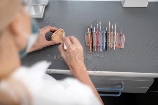 牙齿的技术人员使用擦向干净的瓷假体.
