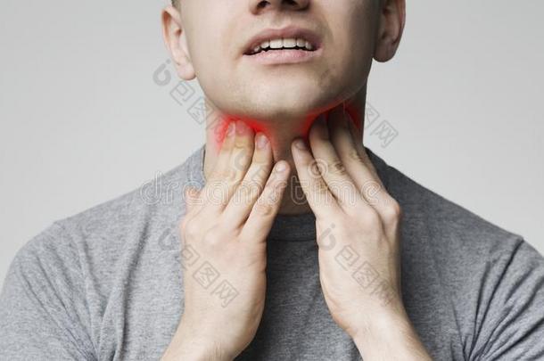 年幼的男人水果的肉质部分他的发炎的颈,关在上面