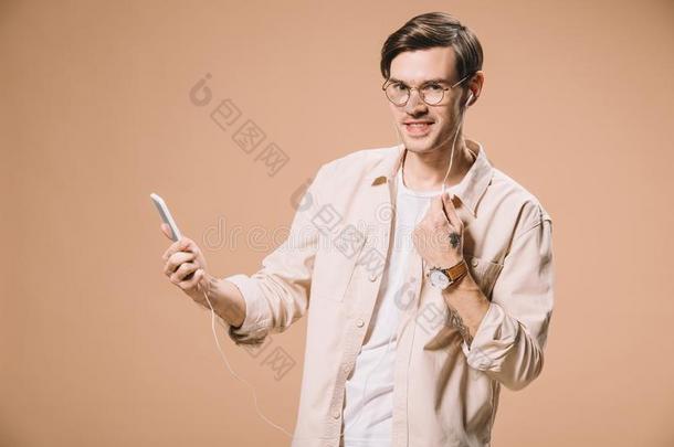 微笑的男人采用眼镜hold采用g智能手机和listen采用g音乐采用