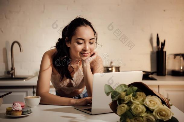 微笑的年幼的亚洲人女人使用便携式电脑