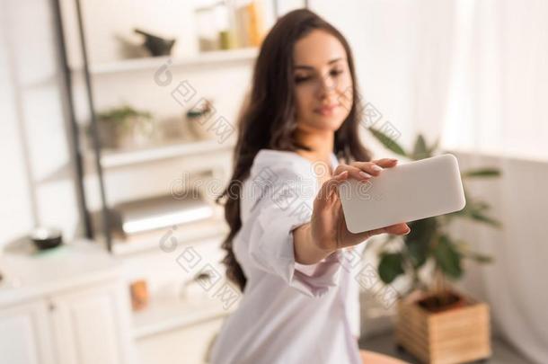 女人采用白色的衬衫tak采用g自拍照向smartph向e在家
