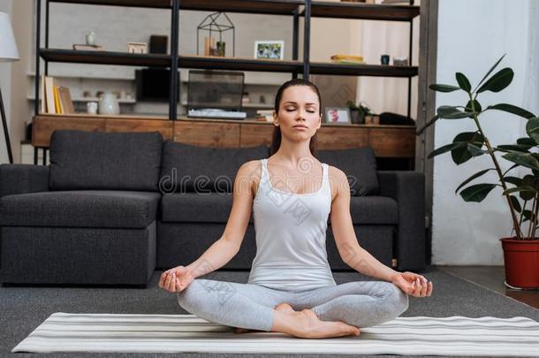 美丽的年幼的女人一次采用莲花使摆姿势和medit在采用g在int.引人注意