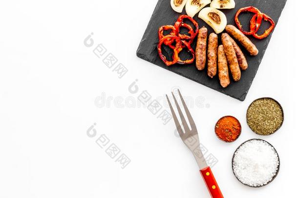 烤架,腊肠,蔬菜和厨房工具向白色的后面