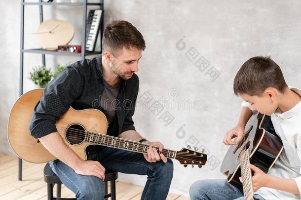年幼的父亲表他的儿子学习向比赛吉他.家庭音乐