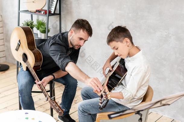两个<strong>兄弟</strong>演奏吉他.年长的<strong>兄弟</strong>教年纪较小者num.一向