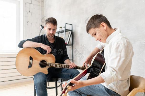 两个兄弟们学习向比赛听觉的吉他.指已提到的人年长的兄弟toxicunit有毒的单位