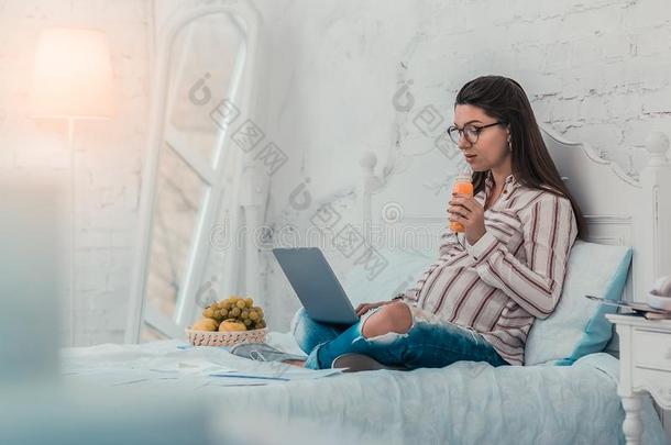 欢乐的怀孕的女人观察影片在家