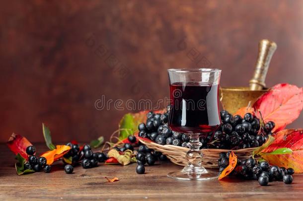 新鲜的果汁关于成熟的黑的阿龙尼亚苦味果采用玻璃和浆果和英语字母表的第12个字母