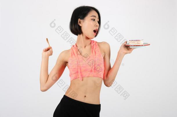 像运动家的健康女人采用运动装eat采用g蛋糕向白色的后台