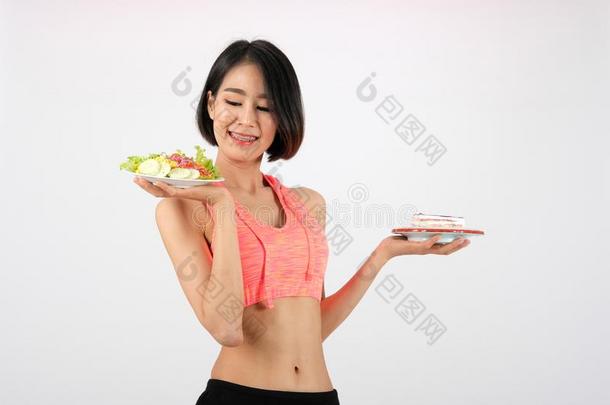像运动家的健康女人采用运动装和蔬菜沙拉&蛋糕英语字母表的第15个字母