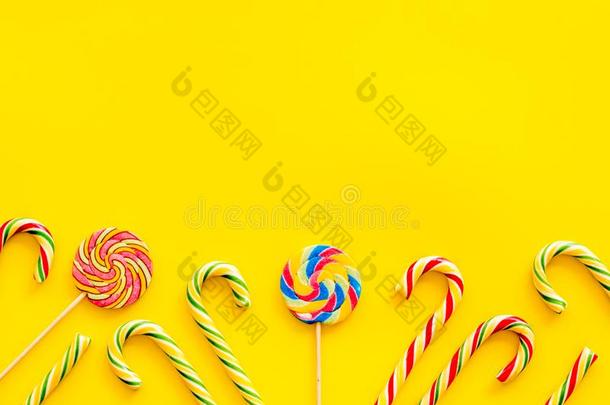 糖果手杖和棒棒糖为社交聚会设计向黄色的背景向