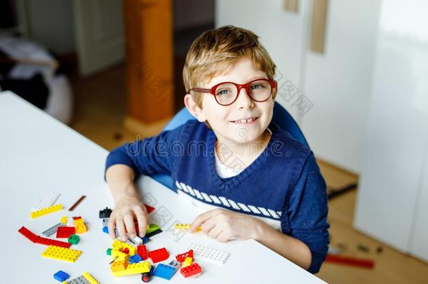 小的亚麻色的小孩和眼睛眼镜演奏和签关于彩色的