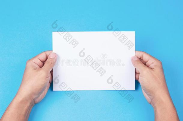 空白的小册子和空白的采用手向蓝色背景
