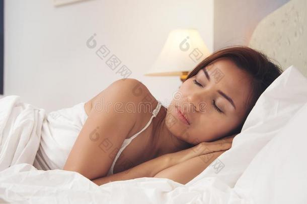 美好亚洲人女人黑的头发睡眠向白色的颜色枕头和