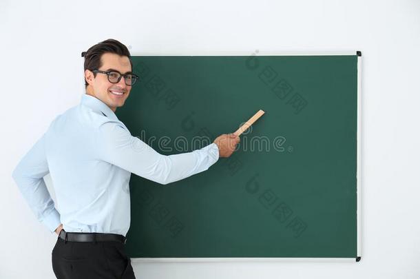 年幼的教师和尺在近处空白的黑板采用教室.休闲健身中心