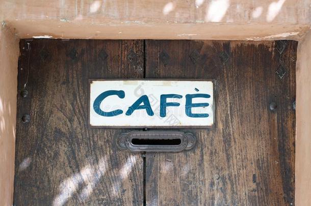 咖啡馆符号向木制的古代的门采用老的建筑物的正面采用欧洲