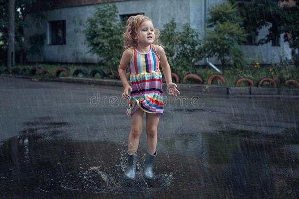 小的女孩用于跳跃的采用指已提到的人水坑