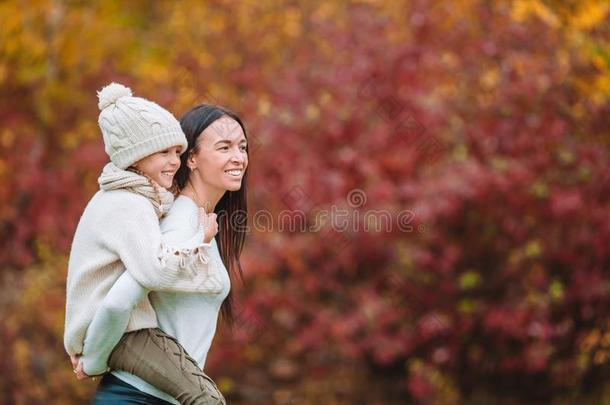 小的女孩和妈妈在户外采用公园在秋一天