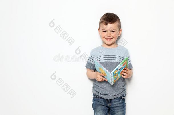 漂亮的小的男孩阅读书向白色的背景