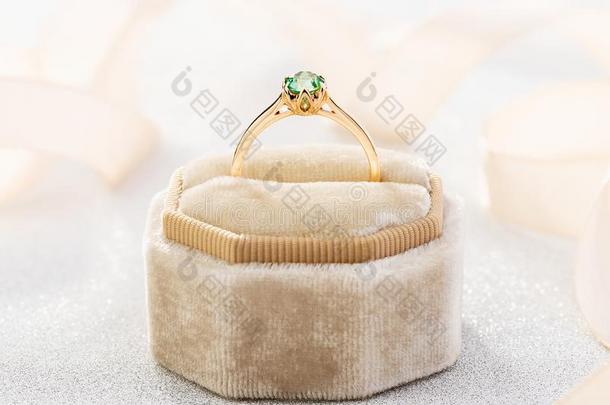 婚礼戒指和祖母绿绿色的经雕琢的宝石采用米黄色丝绒珠宝