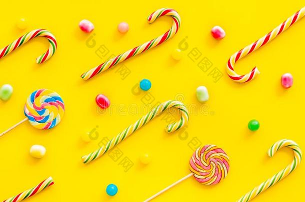 各式各样的糖果,棒棒糖和c和y手杖向黄色的背景向