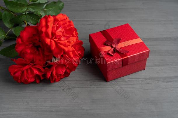 美丽的红色的玫瑰紧接在后的向一赠<strong>品红</strong>色的盒向一d一rk水泥b一ck