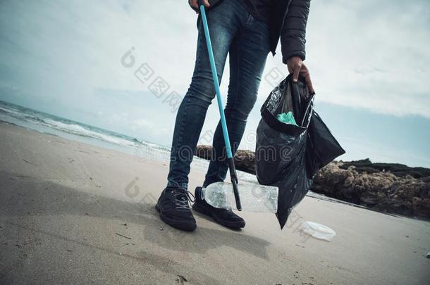 男人收集垃圾向指已提到的人海滩