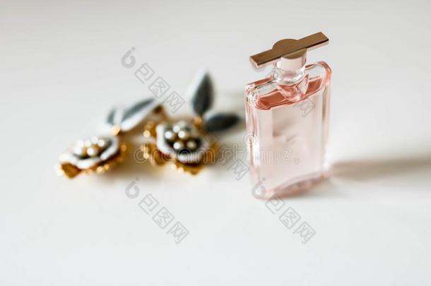 小的帕福姆瓶子和金色的耳环向白色的背景.