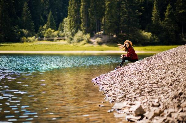 旅行者女人采用稻草帽子休息在近处绿松石蓝色湖和sisterchromatidexchange姐妹染色单体互换