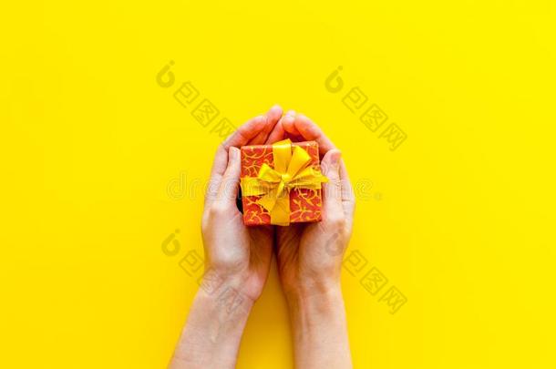 盒为礼物采用手向黄色的背景顶看法愚弄在上面
