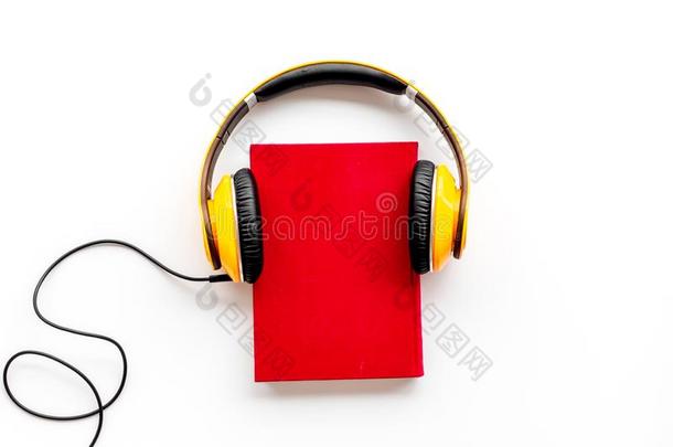 倾听向听觉的书和戴在头上的收话器向白色的背景平坦的