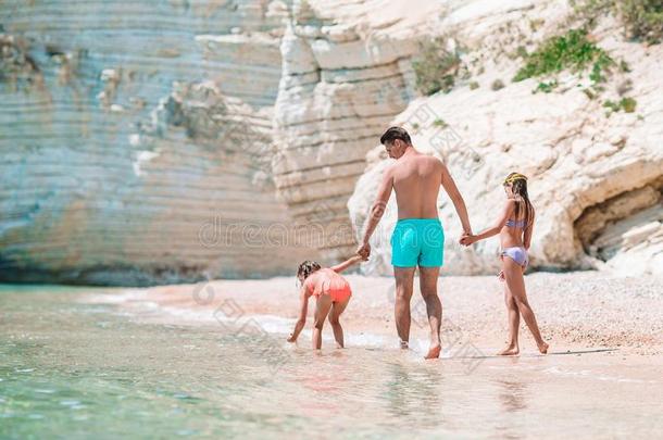 父亲和两个女儿向加勒比海海滩
