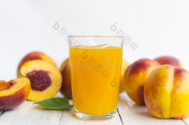 美味的和多汁的桃子蜜桃和玻璃关于果汁向白色的