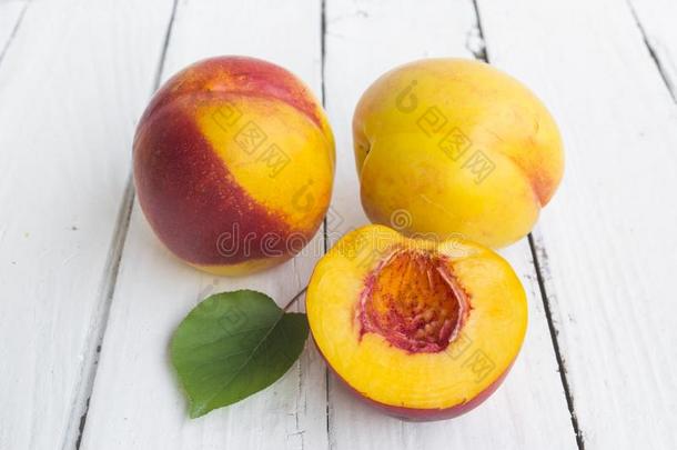 美味的和多汁的桃子蜜桃向白色的木制的表